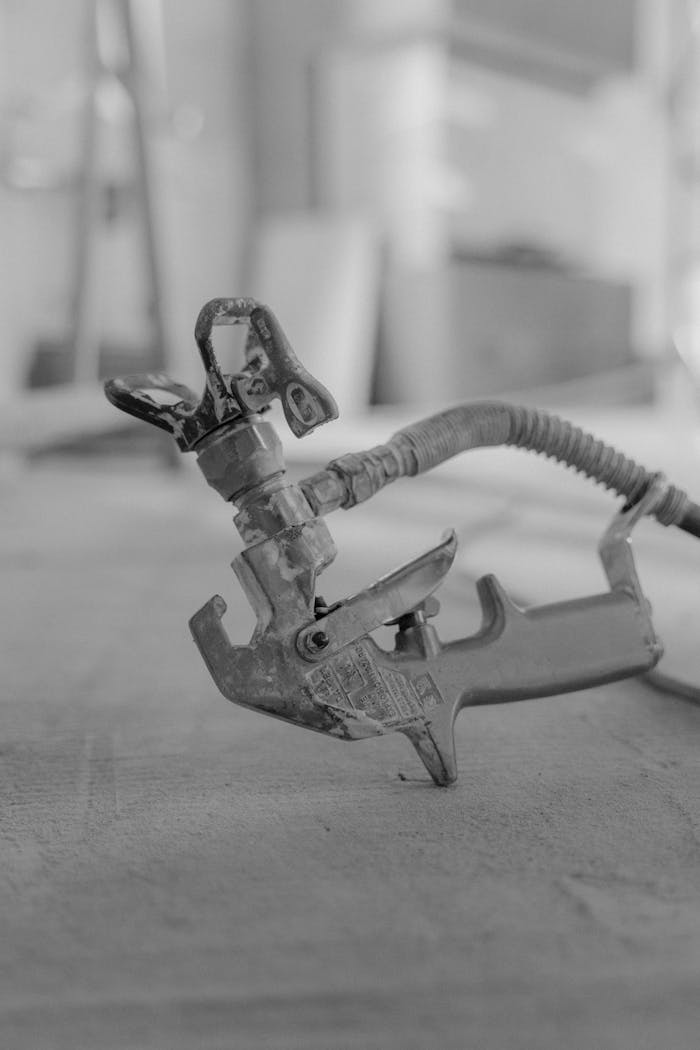 Home Monochrome close-up of a spray gun on a blurred background. Industrial focus.